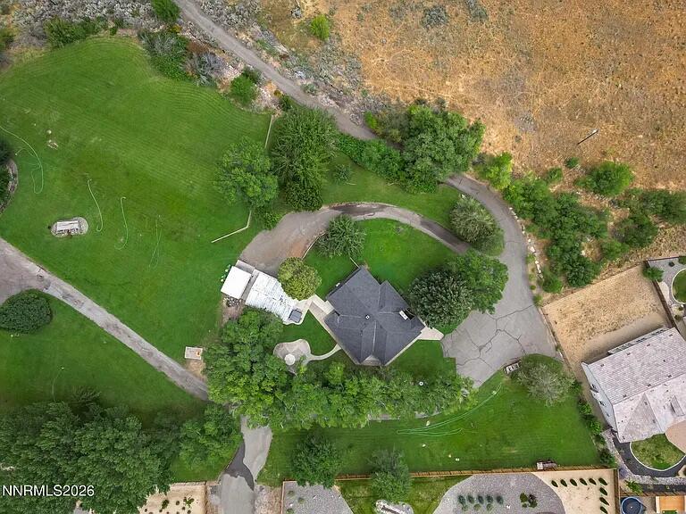 Aerial view of the property with a winding drive and hillside